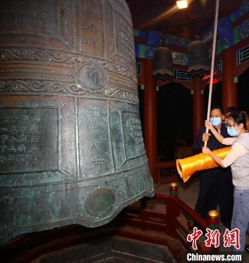 2021年12月31日，游客在三亚南山寺撞钟祈福迎新年。　陈文武 摄